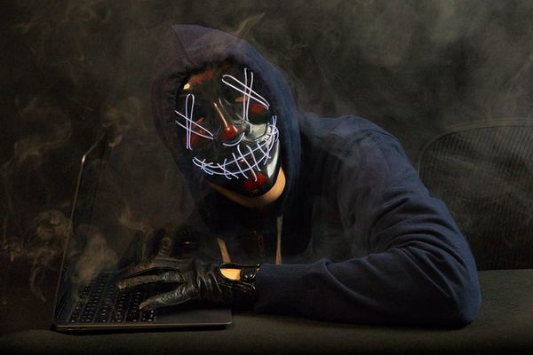 A masked hacker at a keyboard.