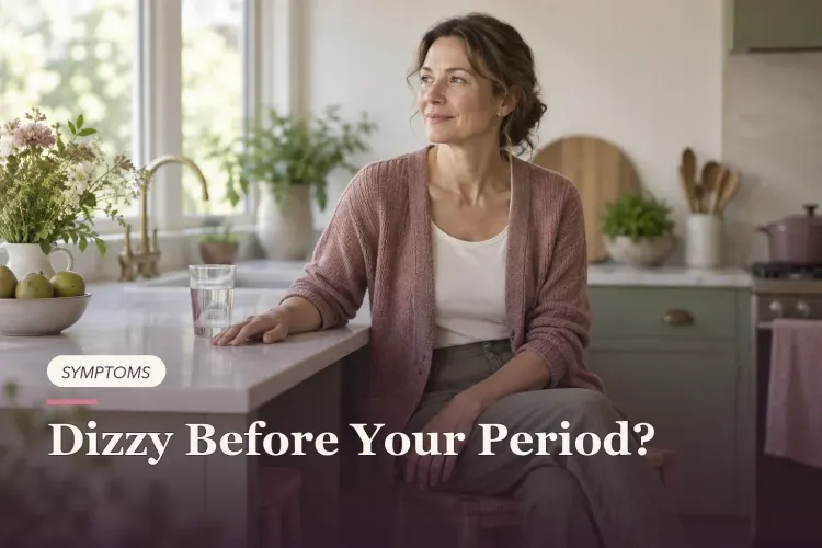 A seated woman steadying herself at a kitchen counter with water nearby.