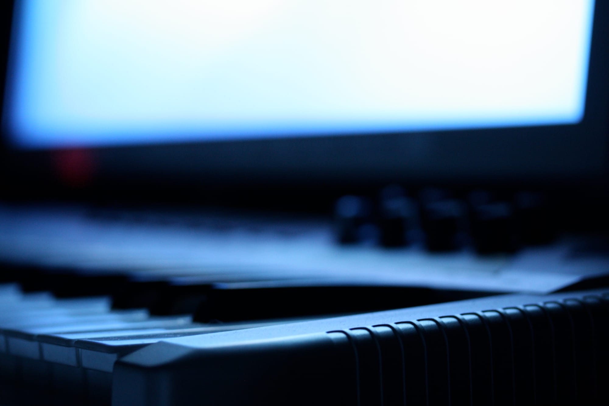 A electronic piano style keyboard in front of a screen