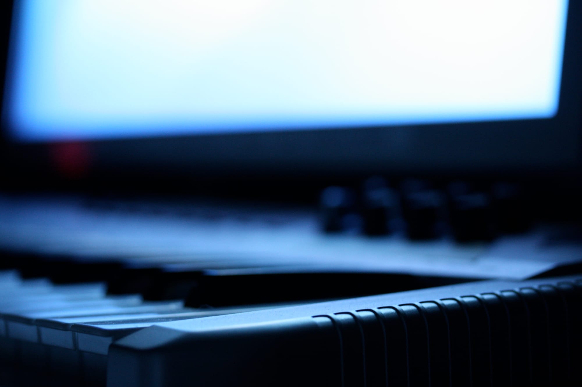 A electronic piano style keyboard in front of a screen