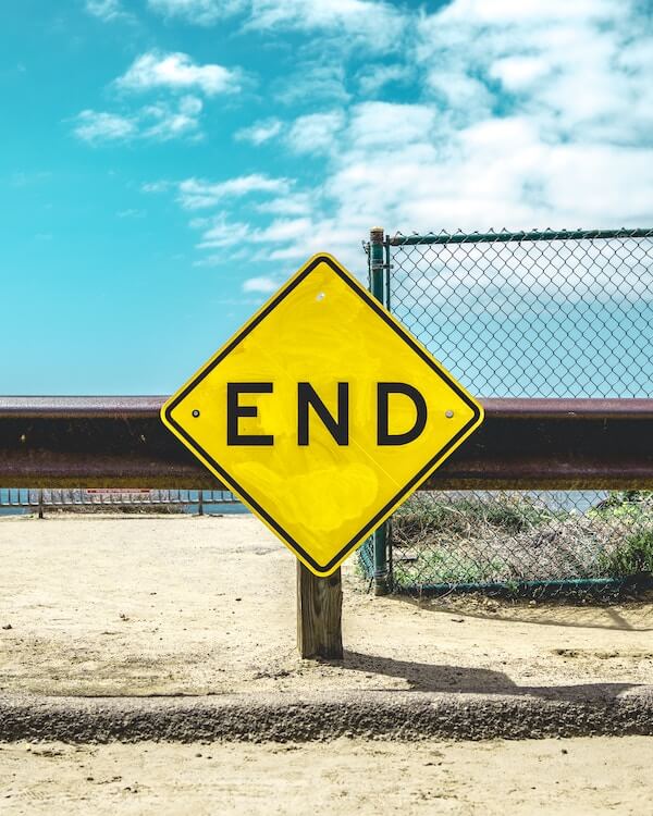 A yellow road sign with the text "End" written on it