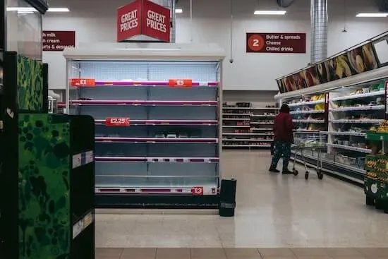 A photograph of empty shelves in a grocery store.