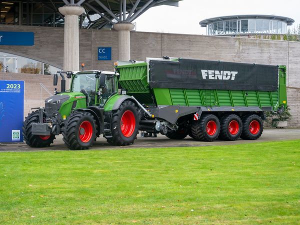A green Fendt 728 Vario tractor with a large forage wagon on display at the Agritechnica trade fair in Hanover.