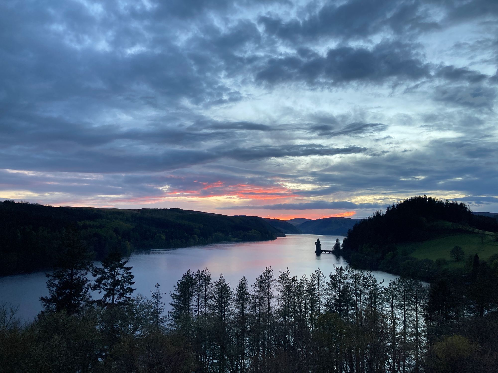 lake at sunset with trees in foreground