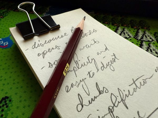 A stack of note cards with jotted notes in cursive handwriting. A sharpened pencil is on top of the cards.