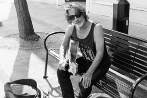 "Man on Bench, Playing Guitar"
