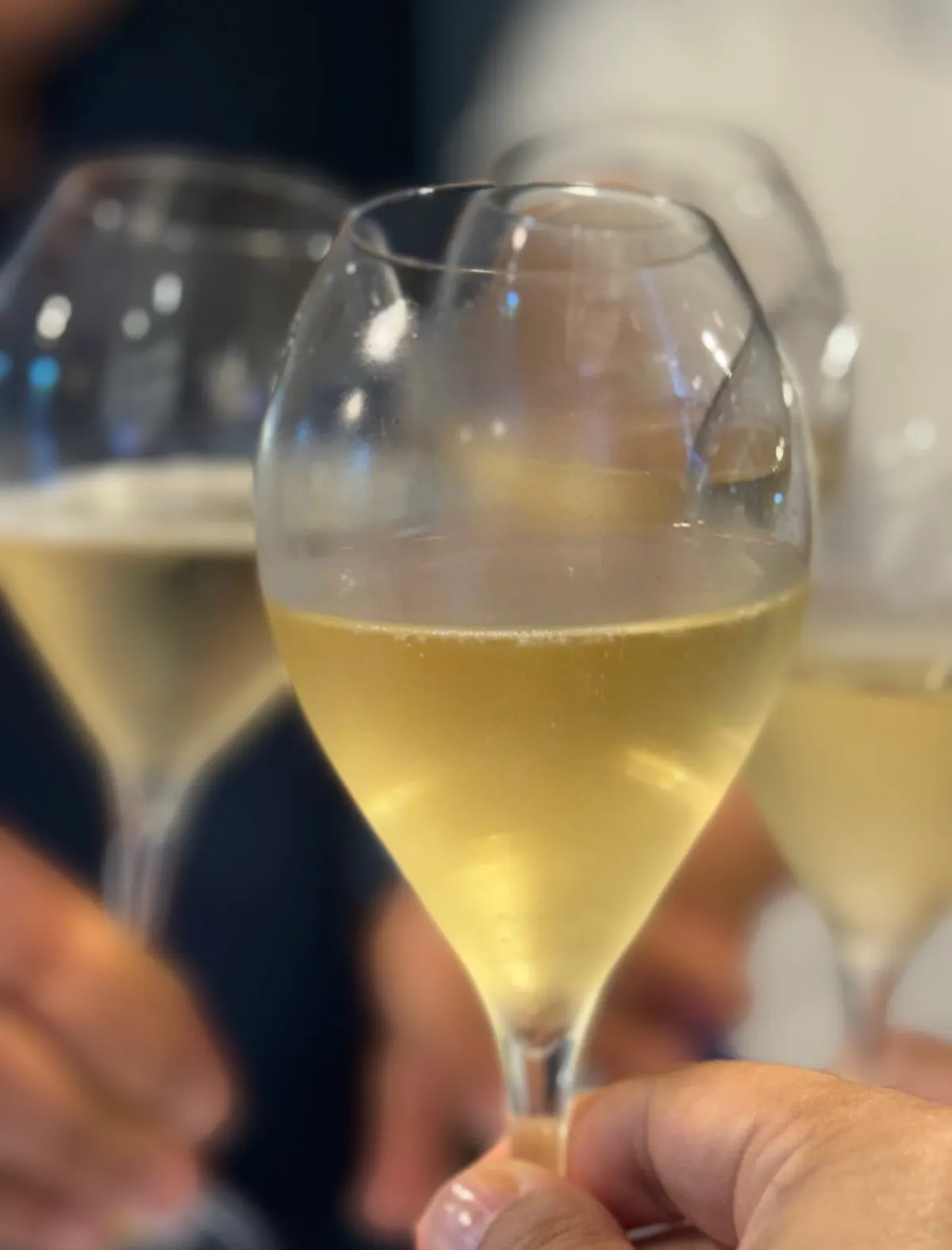Two tulip-shaped glasses of Champagne raised in a toast