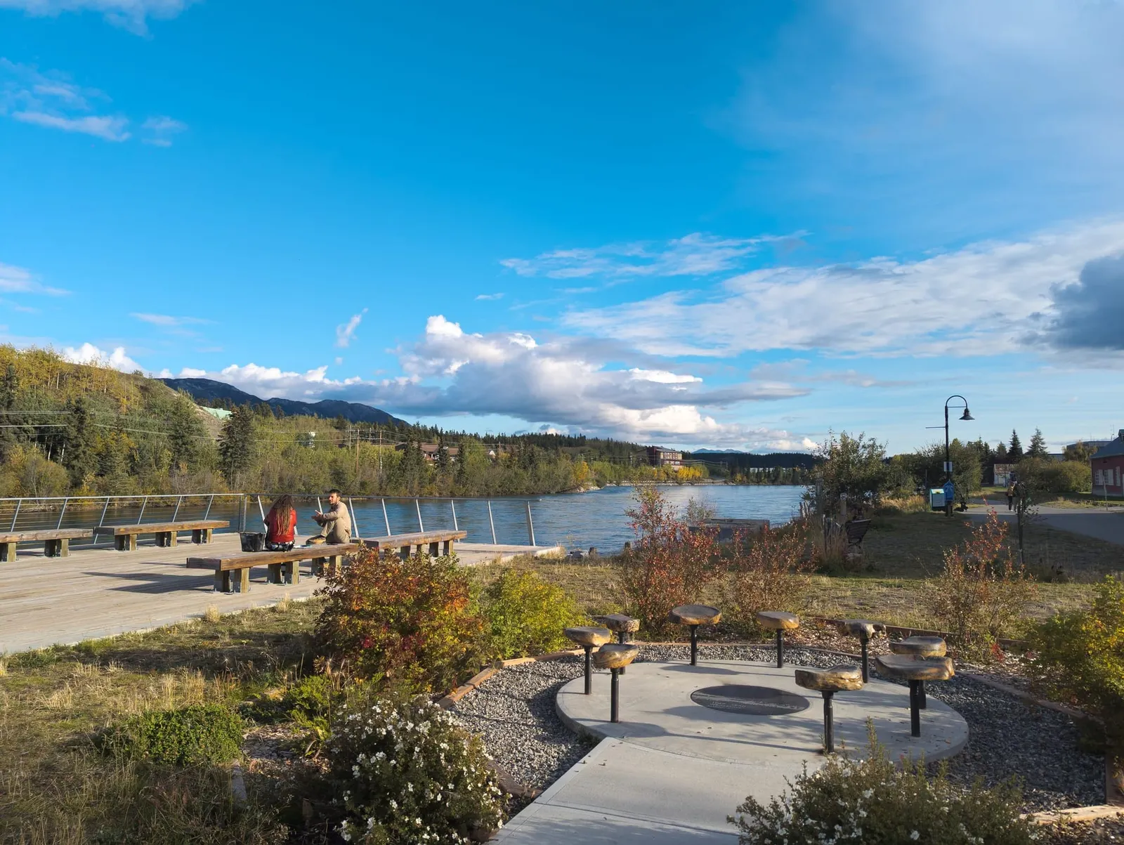 Benches and a stone gathering circle beside the Yukon River on the Whitehorse waterfront in fall