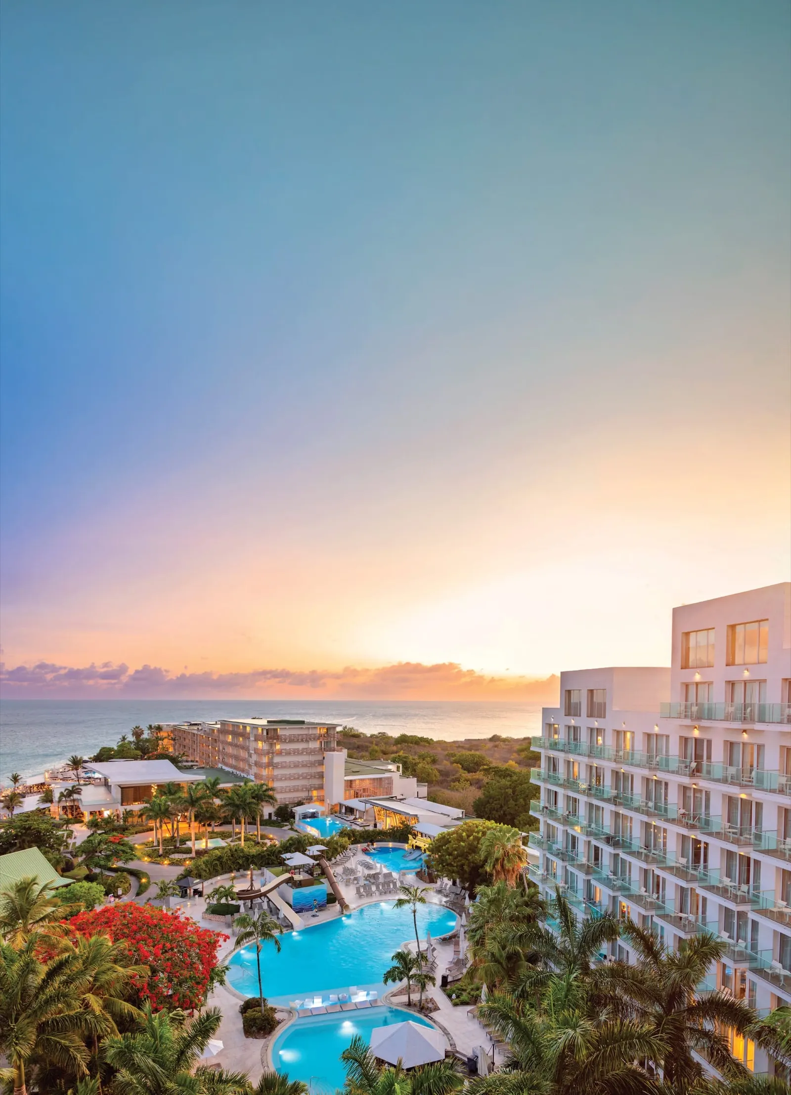 Sonesta Maho Beach Resort at sunset, seen from above, with its pools and palms beside the sea