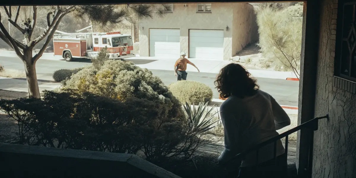 Cal Fire firefighter inspecting a home's defensible space using the official fire hazard map.