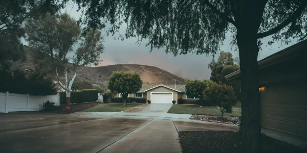 Home with well-maintained defensible space and trimmed trees meeting insurance requirements.