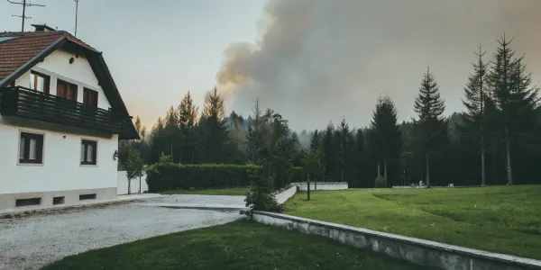 A home at risk from a nearby wildfire, a problem solved by wildfire mitigation for homeowners.