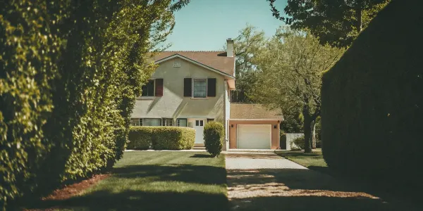 A home's well-maintained defensible space with a clear yard and trimmed plants for wildfire protection.