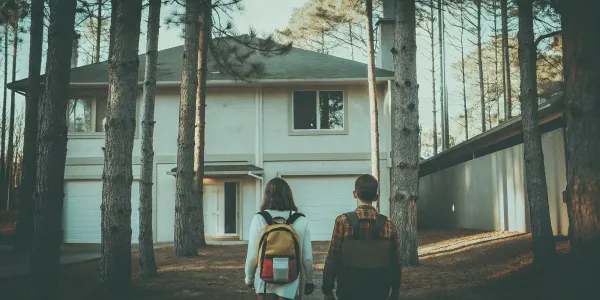 A family with go-bags stands outside their home, following their wildfire evacuation plan.