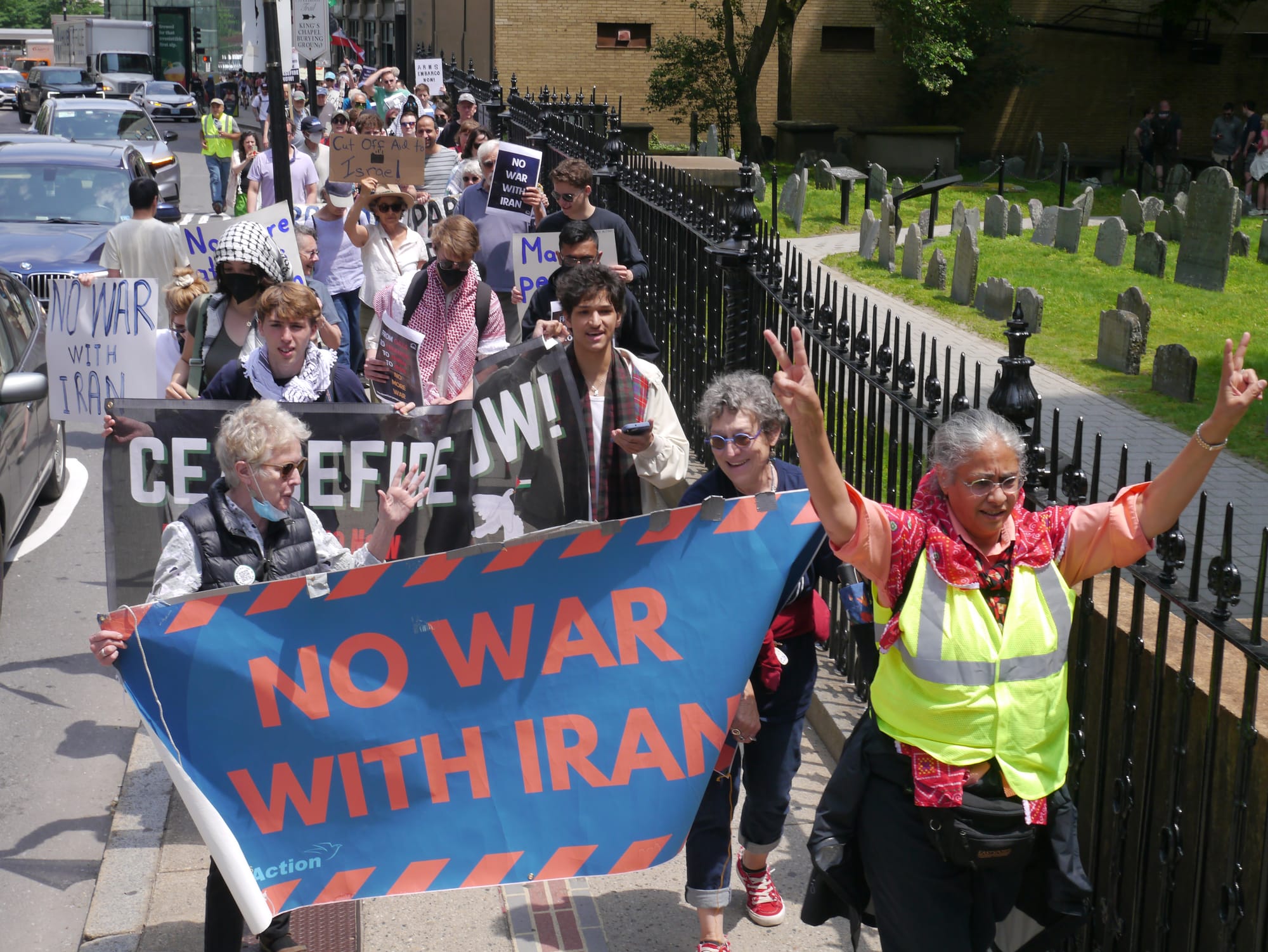 Protestors carry a "No war with Iran" banner along Tremont Street in downtown Boston.