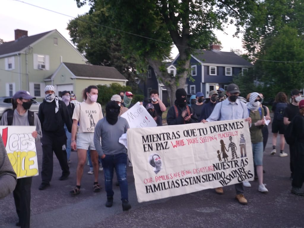 Protesters walk with sign that reads "While you're sleeping peacefully, our families are being disappeared."