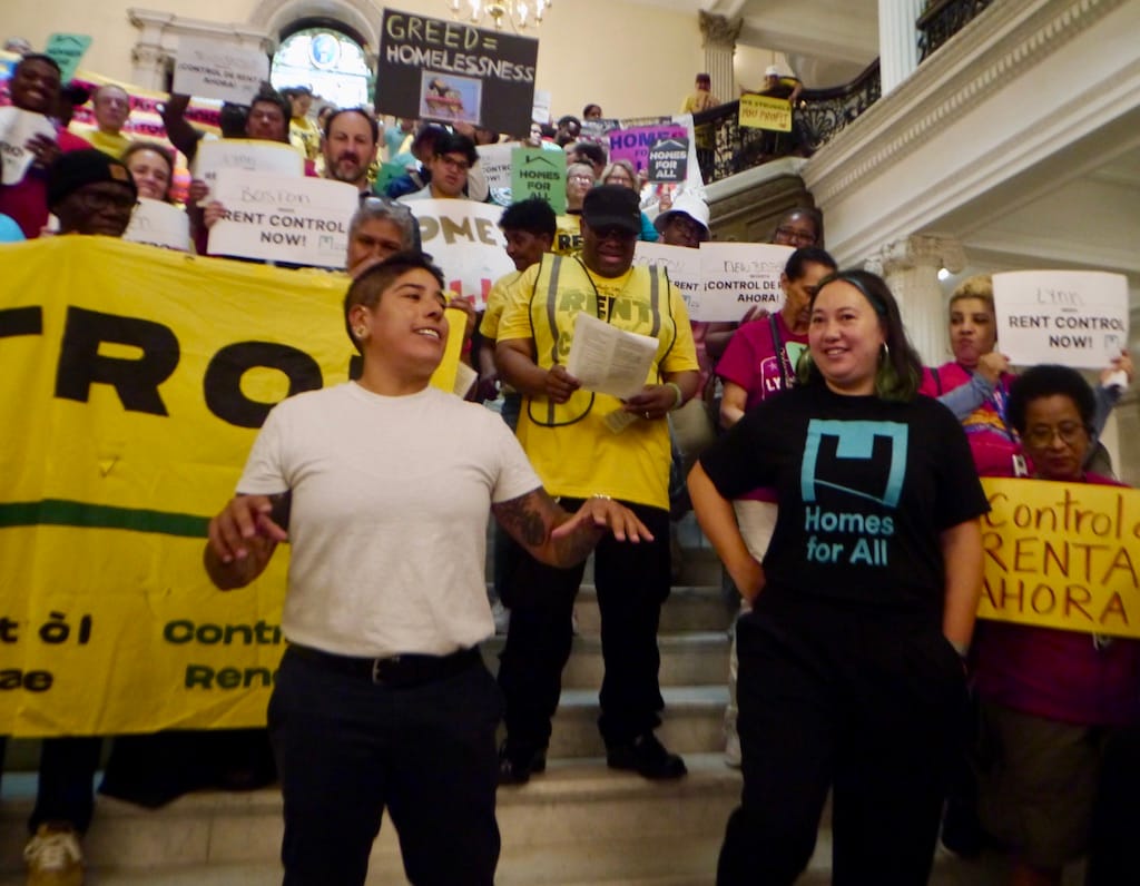 State Rep. Sam Montaño and Carolyn Chou, executive director of Homes For All Massachusetts, lead a rally at the Grand Staircase in the State House.