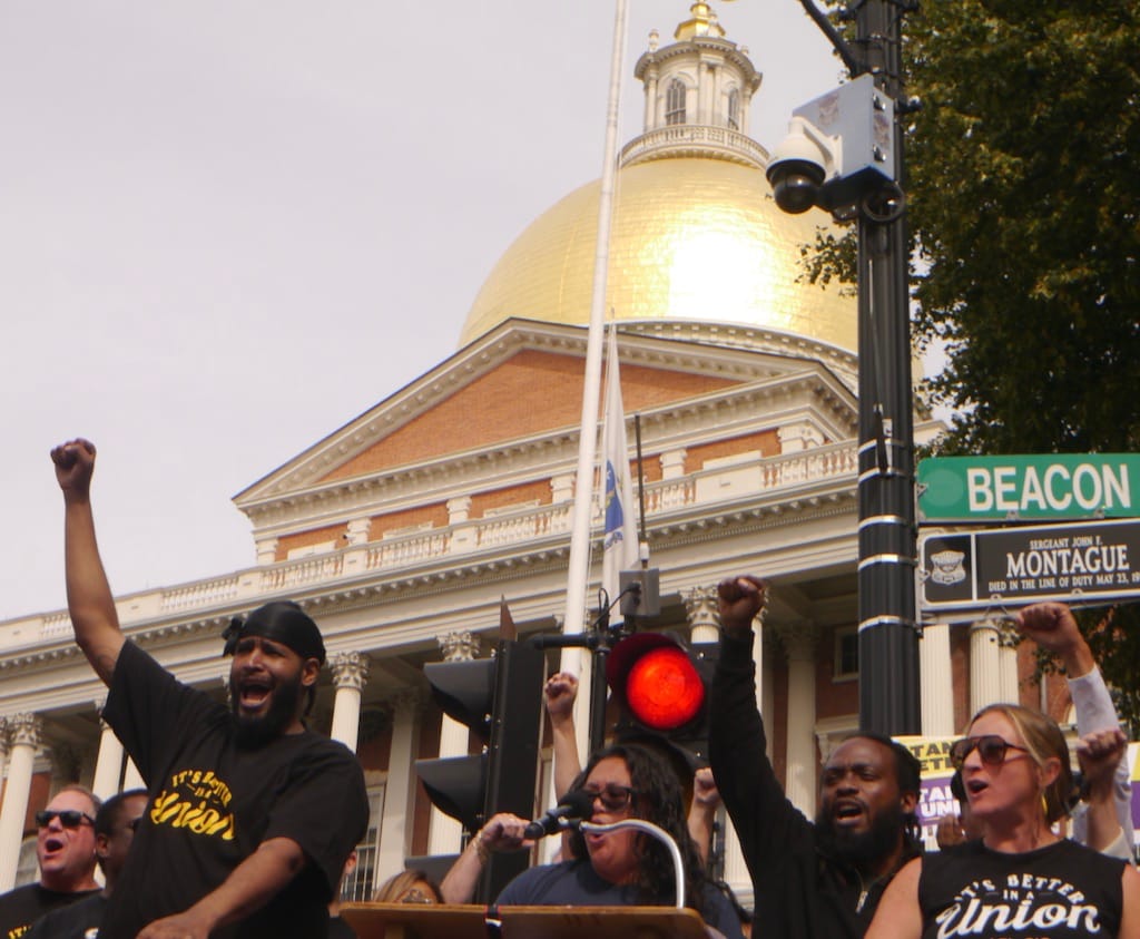 Greater Boston Labor Council President Darlene Lombos rallies activists gathered in front of the State House.