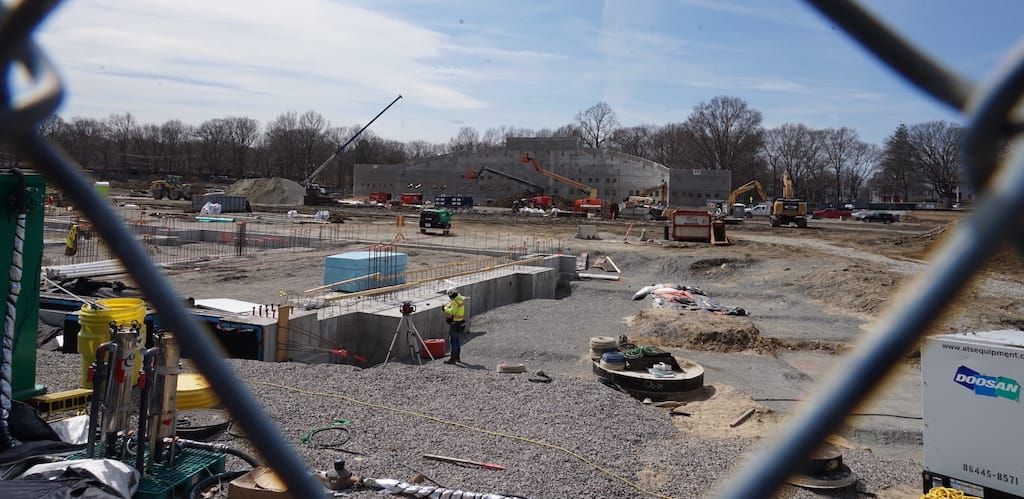 Foundations are poured for the White Stadium construction project seen through a chain-link fence.