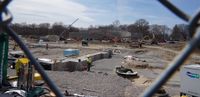 Foundations are poured for the White Stadium construction project seen through a chain-link fence.