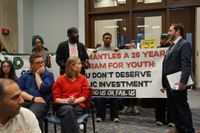 Activists question City Councilor Ben Webber in a protest that interrupted a working session in the Council's Piemonte Room.