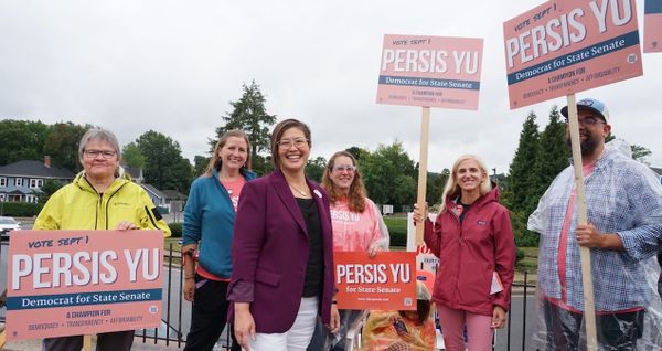 Attorney and consumer advocate Persis Yu stands with supporters outside the Holy Name Parish polling location in West Roxbury. Yu defeated incumbent Sen. Michael Rush in the Tuesday primary.