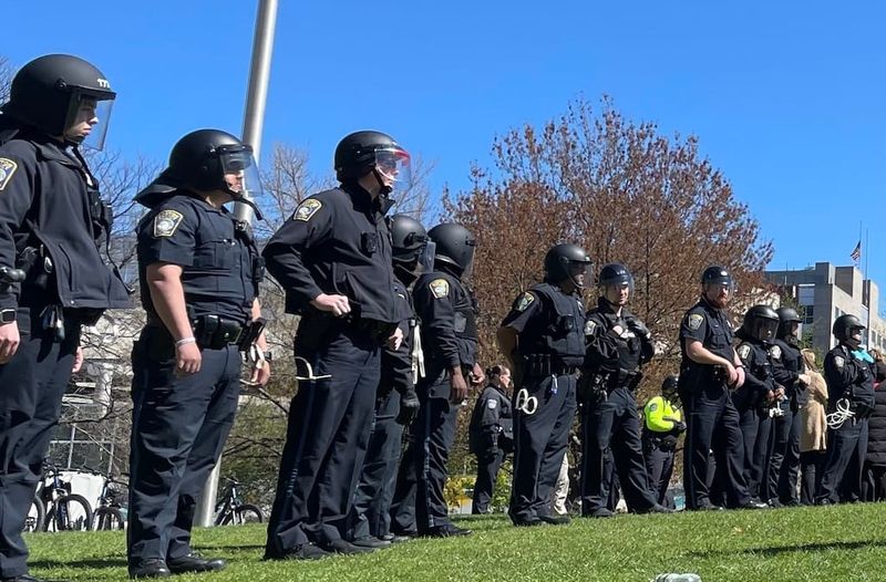 Boston police officers in riot gear face protesters at Northeastern University in 2024.
