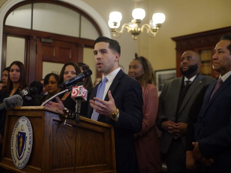 Surrounded by state representatives, Mass. Black and Latino Legislative Caucus Chair Andy Vargas addresses reporters at the State House. 