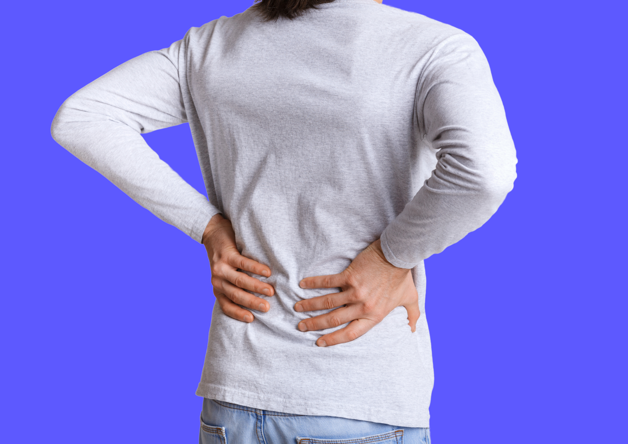 Man holds onto his lower back since he suffers from back pain. Blue background.