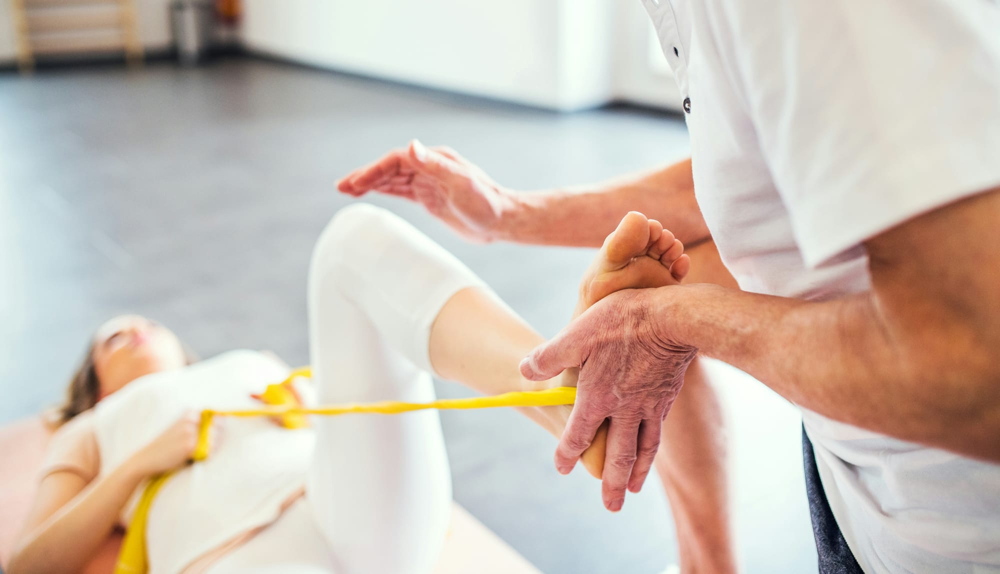 Woman doing stretching exercise with physiotherapist.