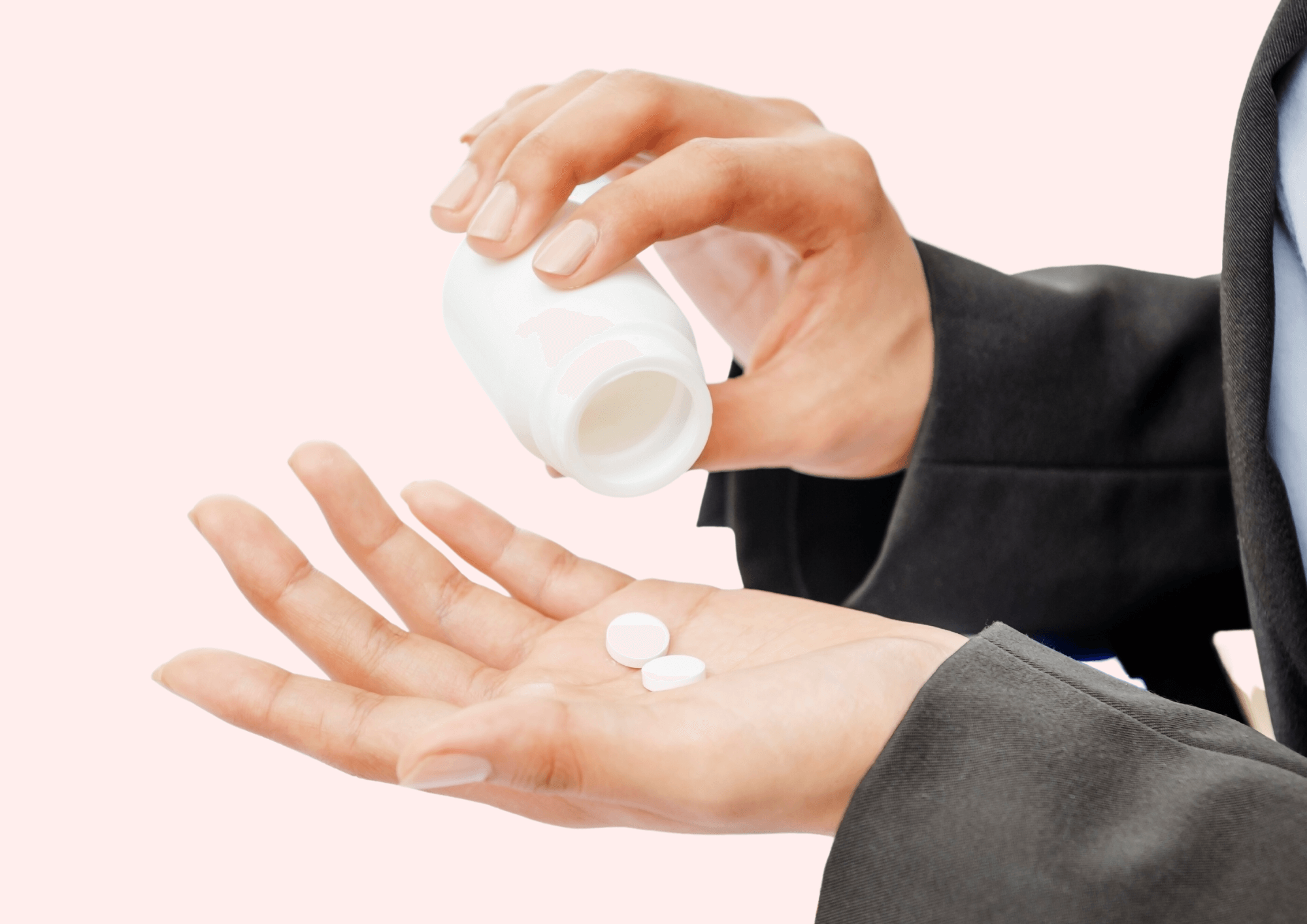 Frau hält Schmerztabletten in der Hand.
