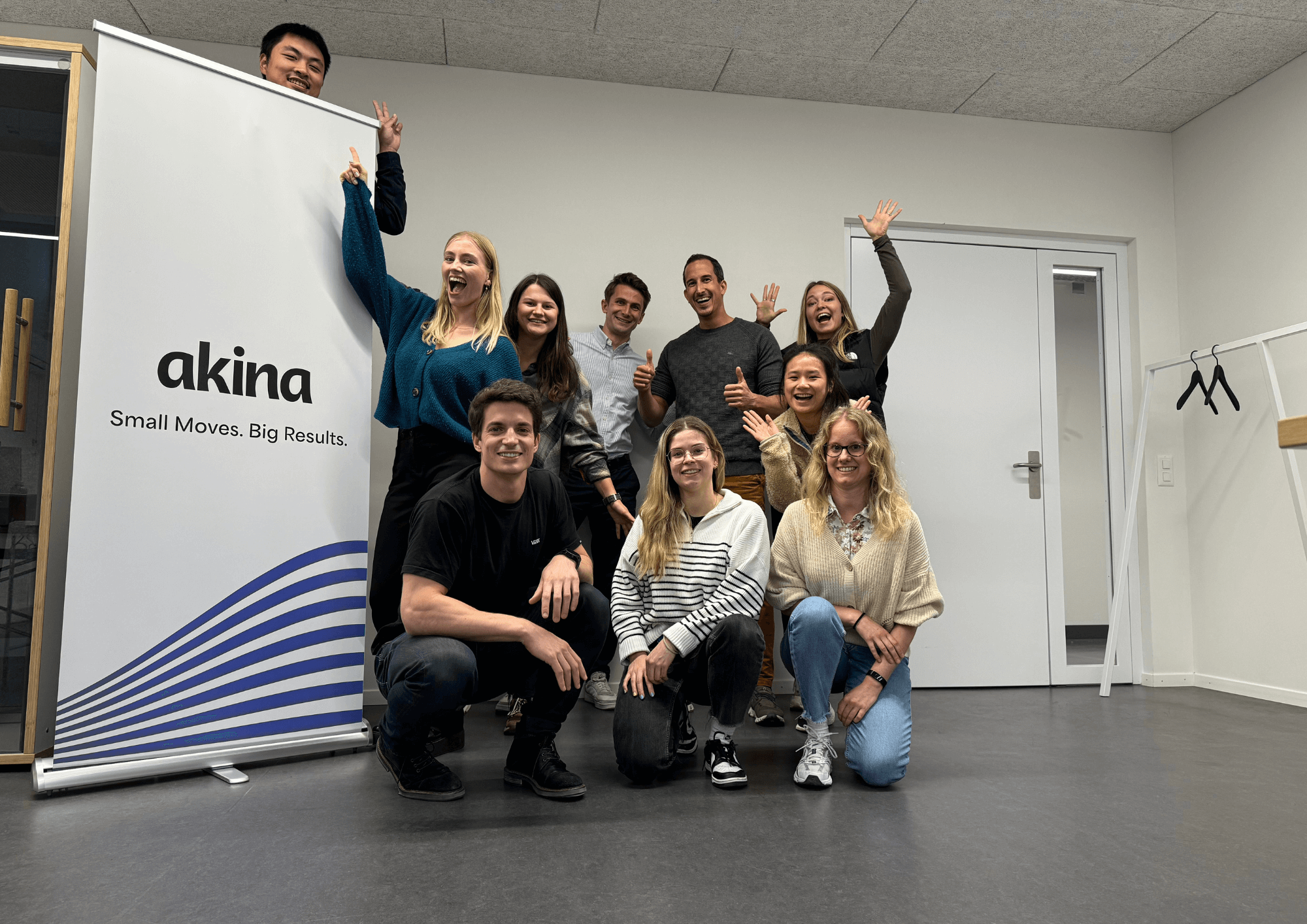 Gruppen Foto von Akina Team, jubelnd. Akina: Small moves. Big results.