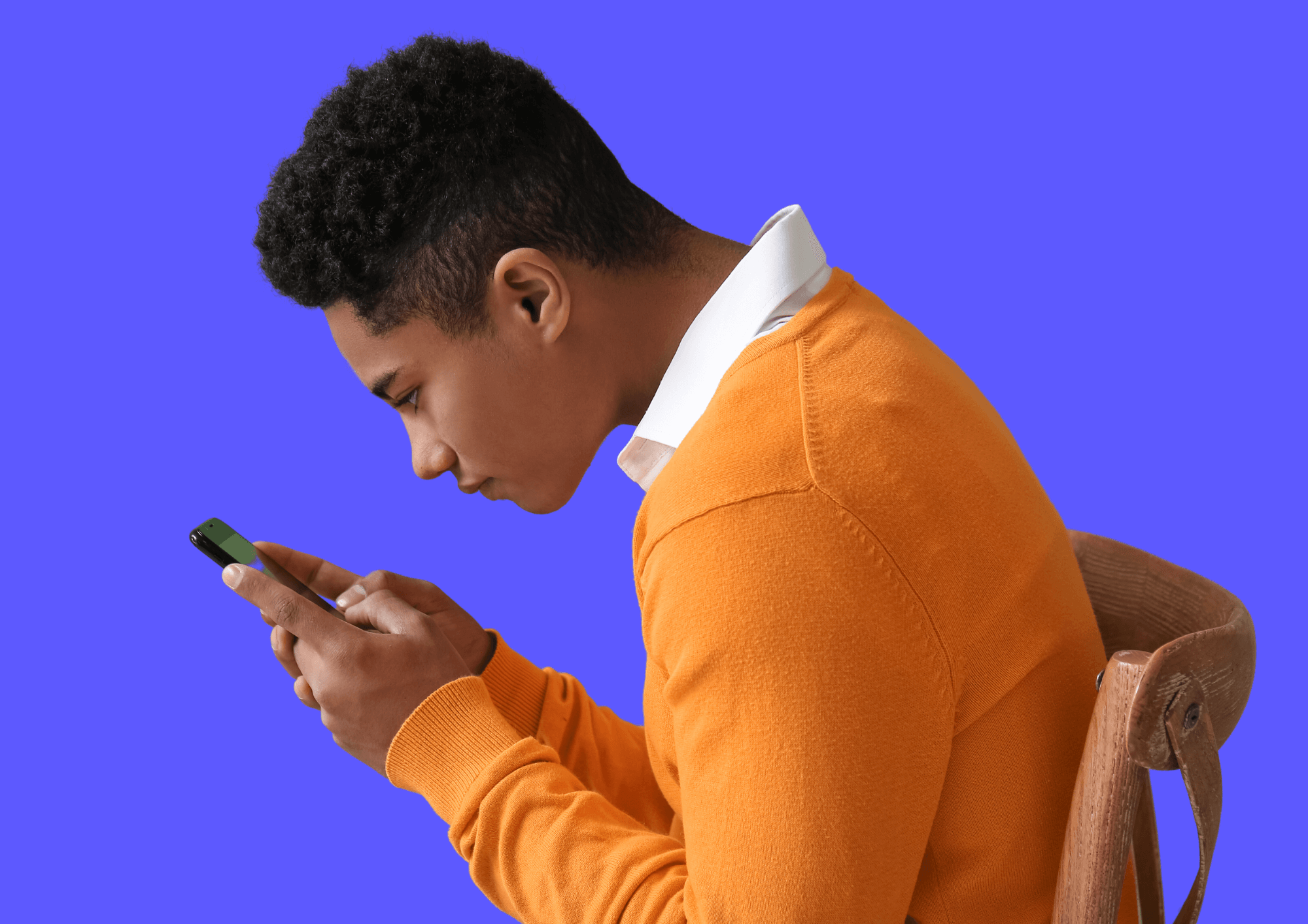 Young boy stares into Smartphone with bad neck posture.