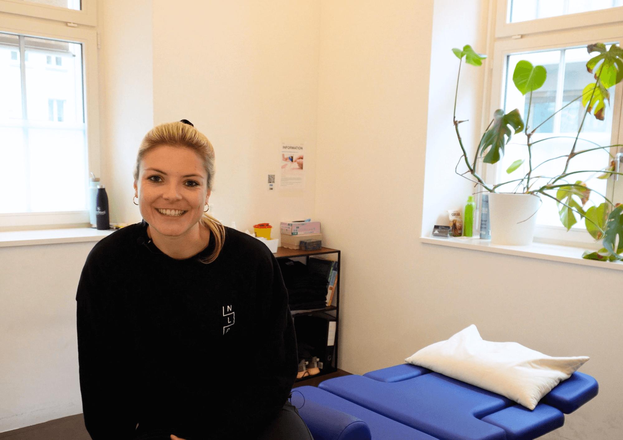 Fabienne sitzt auf Massage-Liege in der Physio-Praxis.