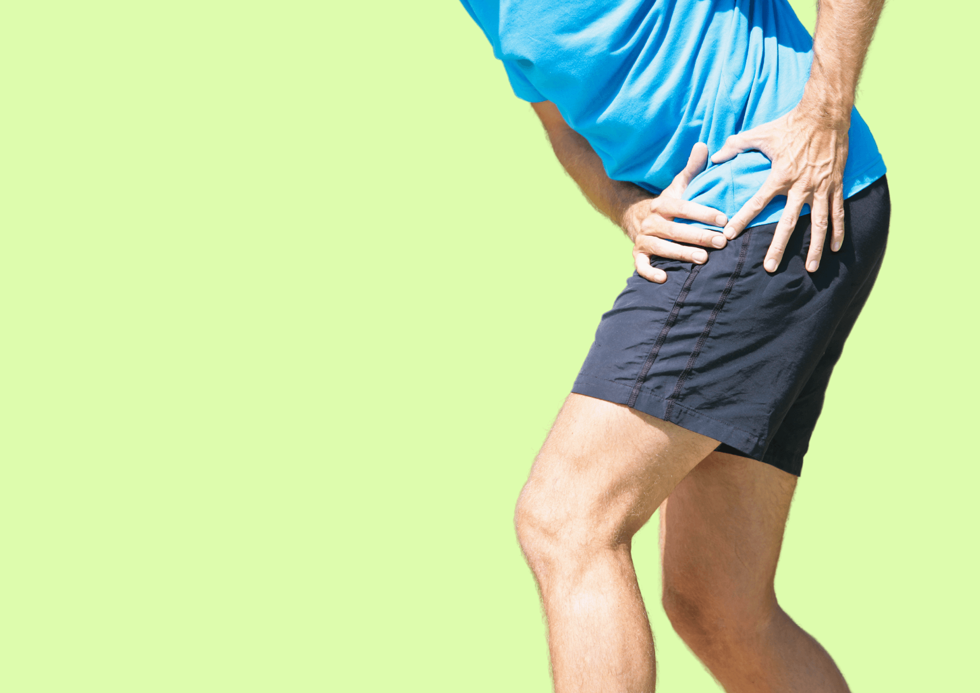 Mann beim Sport fasst sich vor Schmerz an die Hüfte.