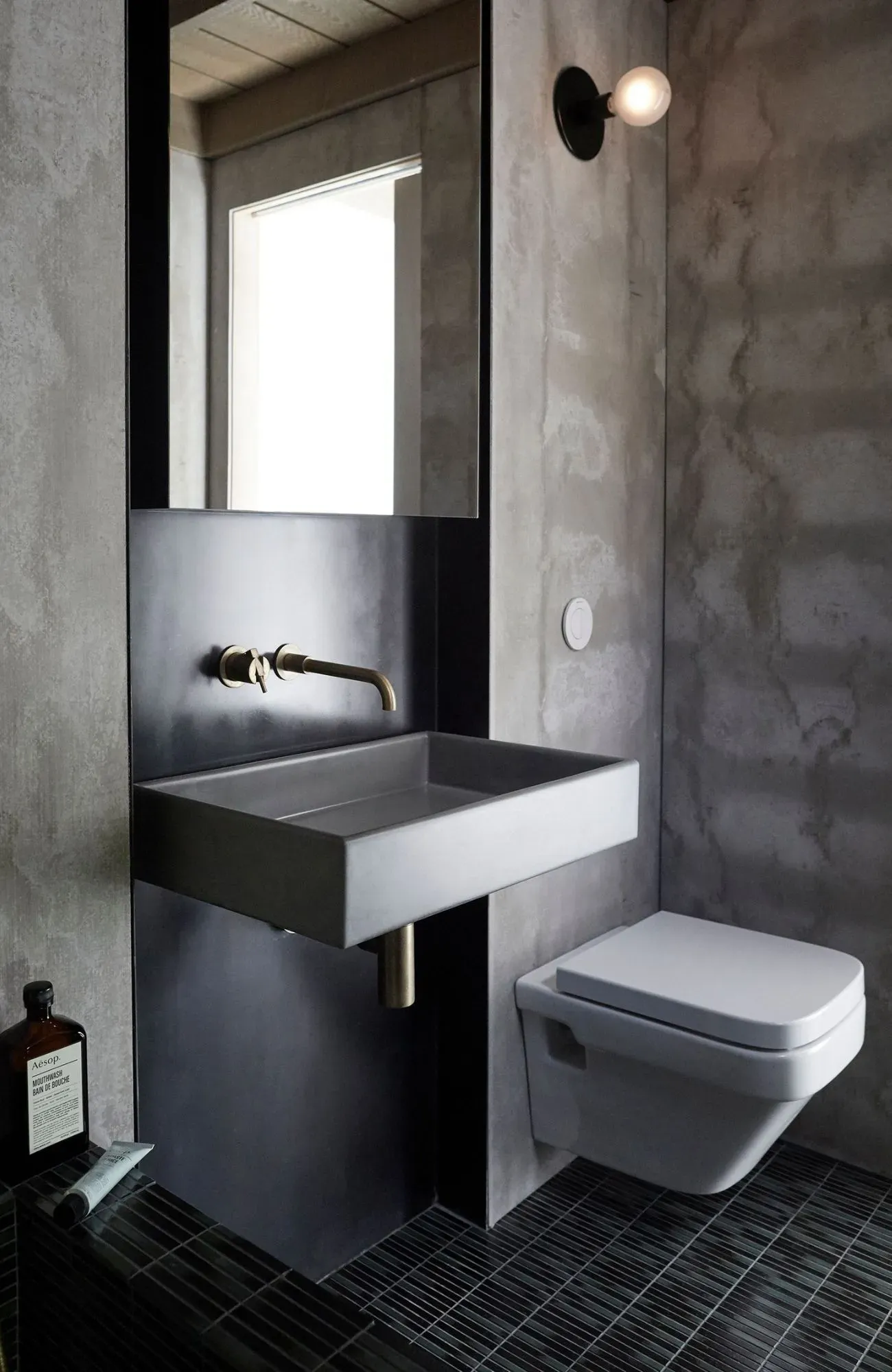Cedar Cabin by Nicholas Gurney & Monique Easton. Styled bathroom featuring basin, mirror and brass accents.