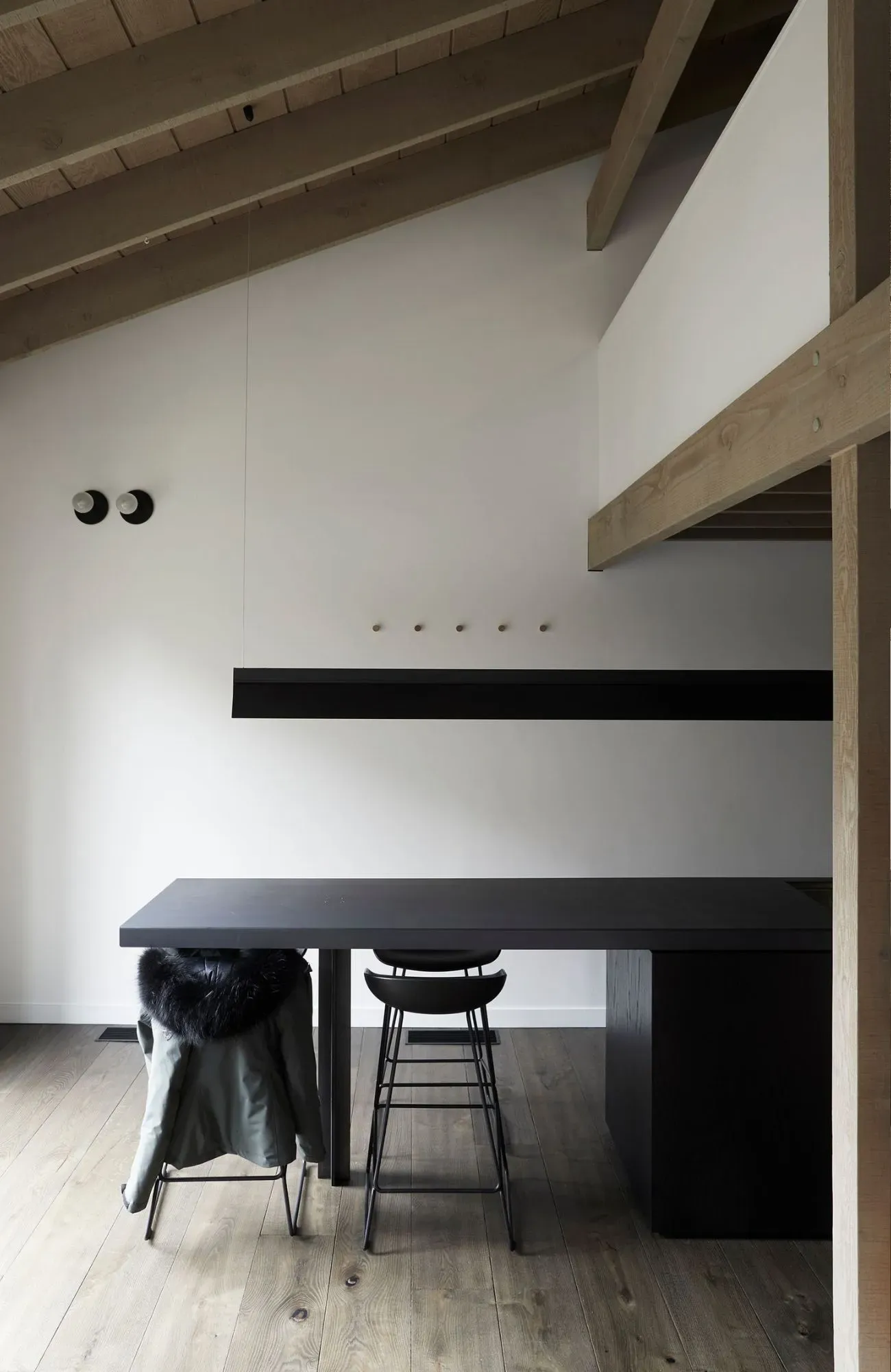 Cedar Cabin by Nicholas Gurney & Monique Easton. Kitchen dining area, stool seating styled with a fur winter jacket.