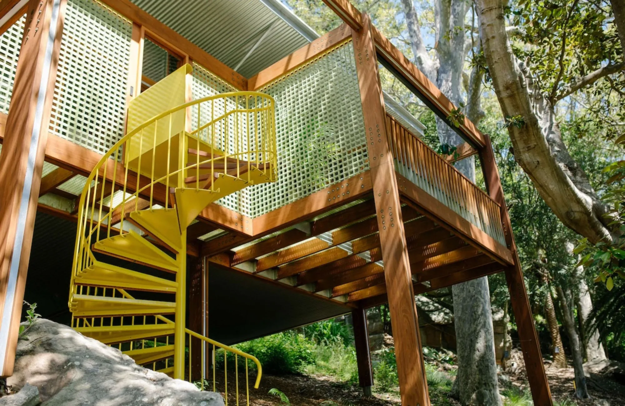 Balmy Palmy by CplusC Architectural Workshop. Facade view of yellow spiral staircase from ground level 