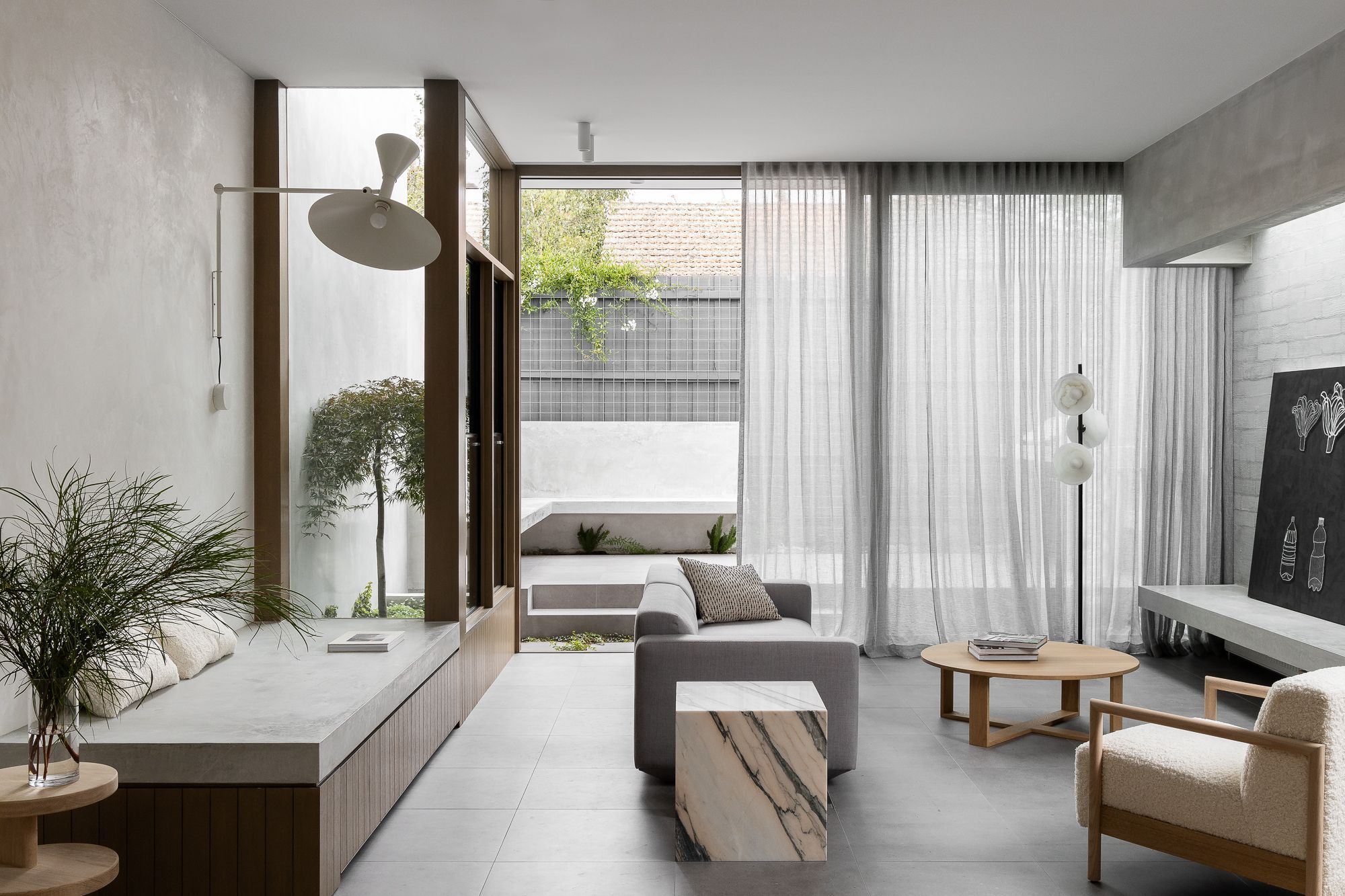 Ripponlea House by Luke Fry Architecture and Interior Design. Living room view, sliding doors opening up to sun-bathed courtyard.