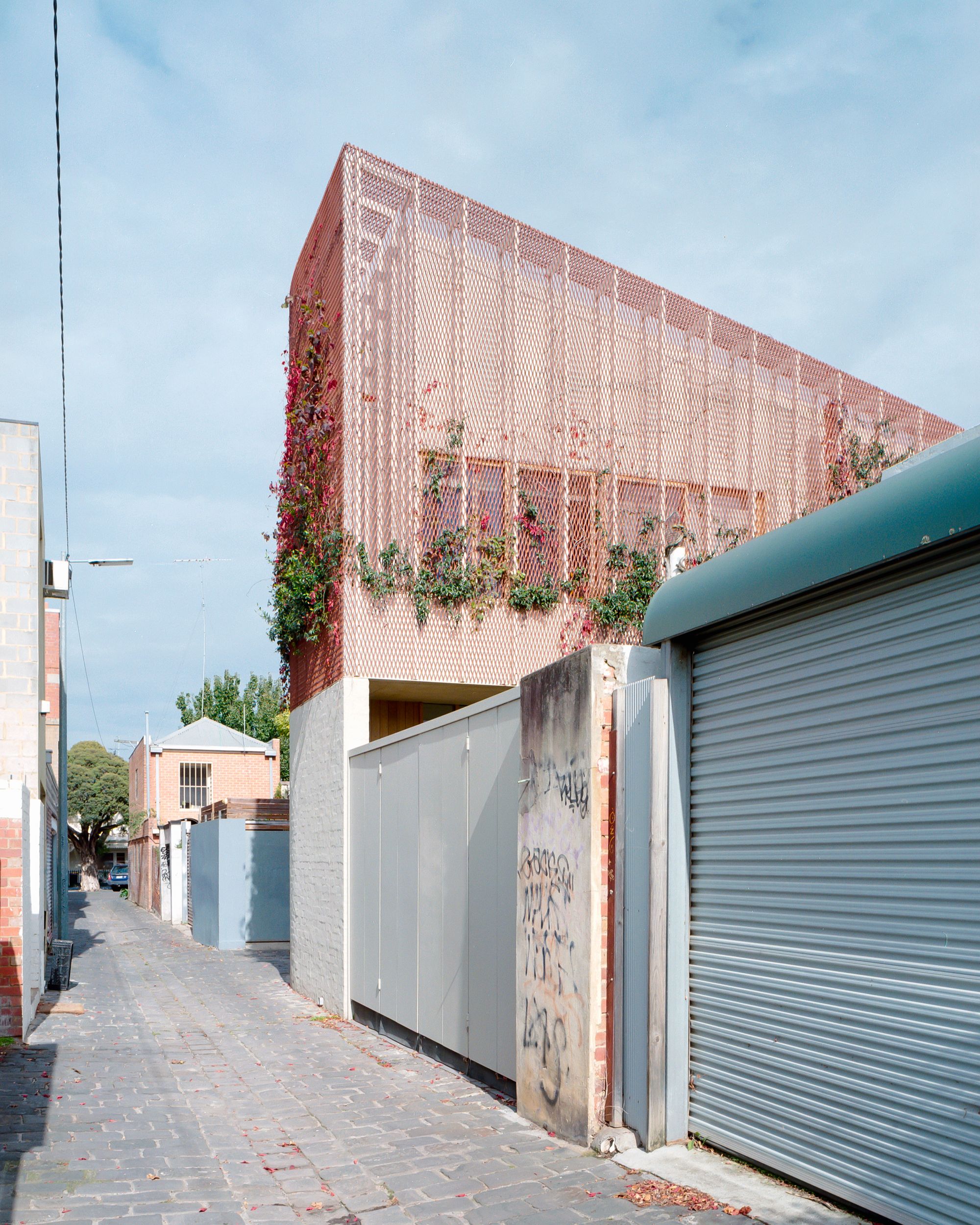 Autumn House by&nbsp;Studio Bright. Street view from rear of home, Contrasting tones of red and blue 