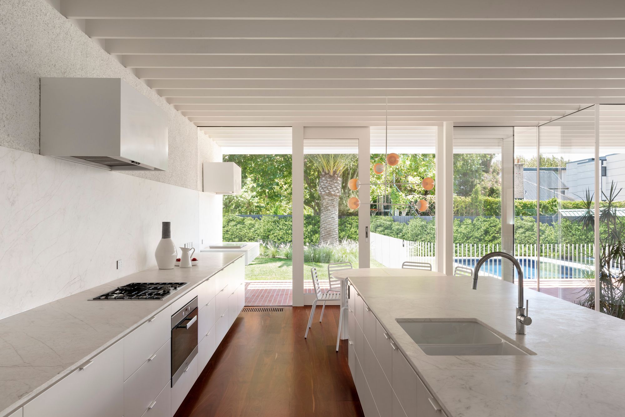 Elwood House by AM Architecture showing kitchen interior with white marble and white joinery