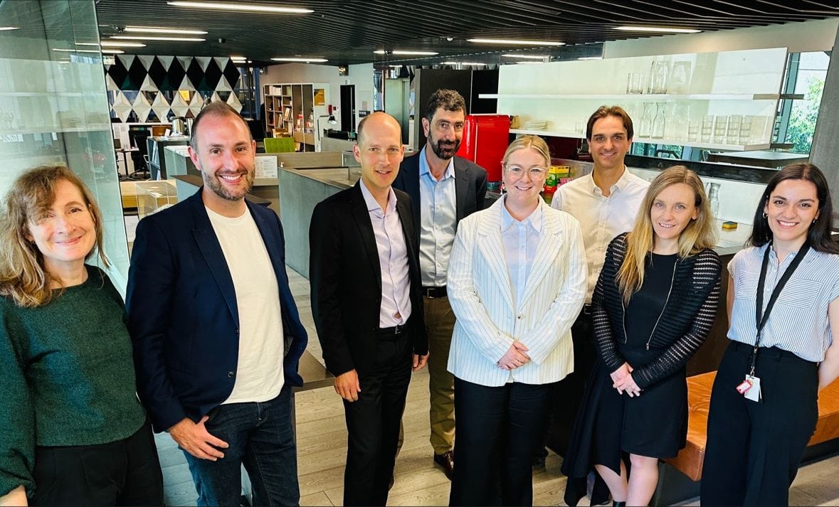 Eight people standing in an office 