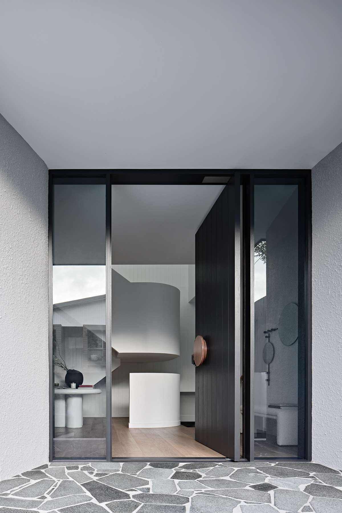 Amiri Courtyard House by Kelder Architects showing front door and glimpse of sculptural stair