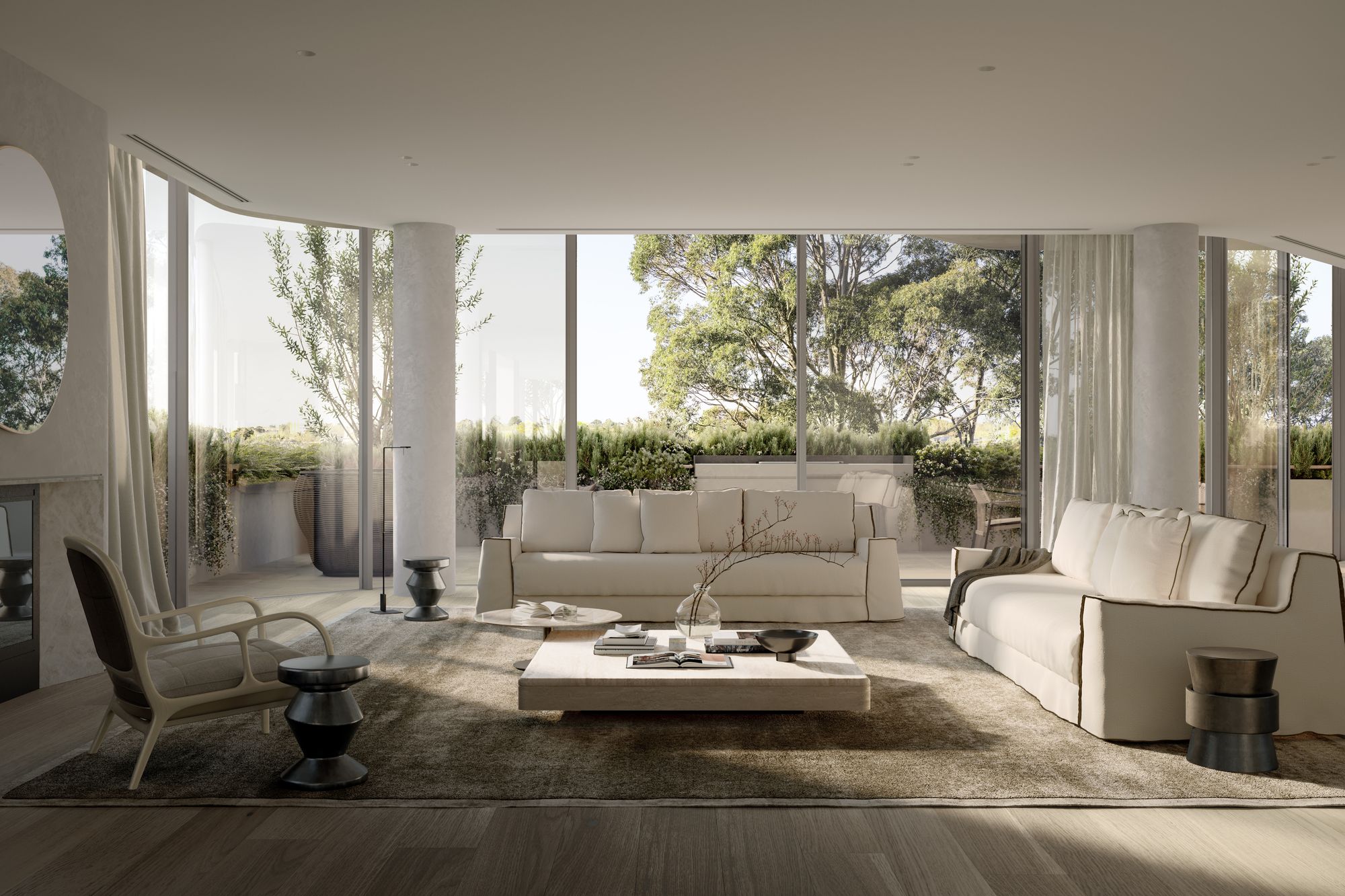 The image showcases a spacious and luxurious living room with a modern design. The room features floor-to-ceiling windows draped with sheer curtains, allowing for a view of a serene outdoor terrace and lush greenery. The space is furnished with a large, comfortable off-white sofa, a stylish armchair, and contemporary side tables. A large, textured area rug anchors the seating area, while a minimalist coffee table holds decorative items, contributing to the room's elegant and tranquil ambiance.