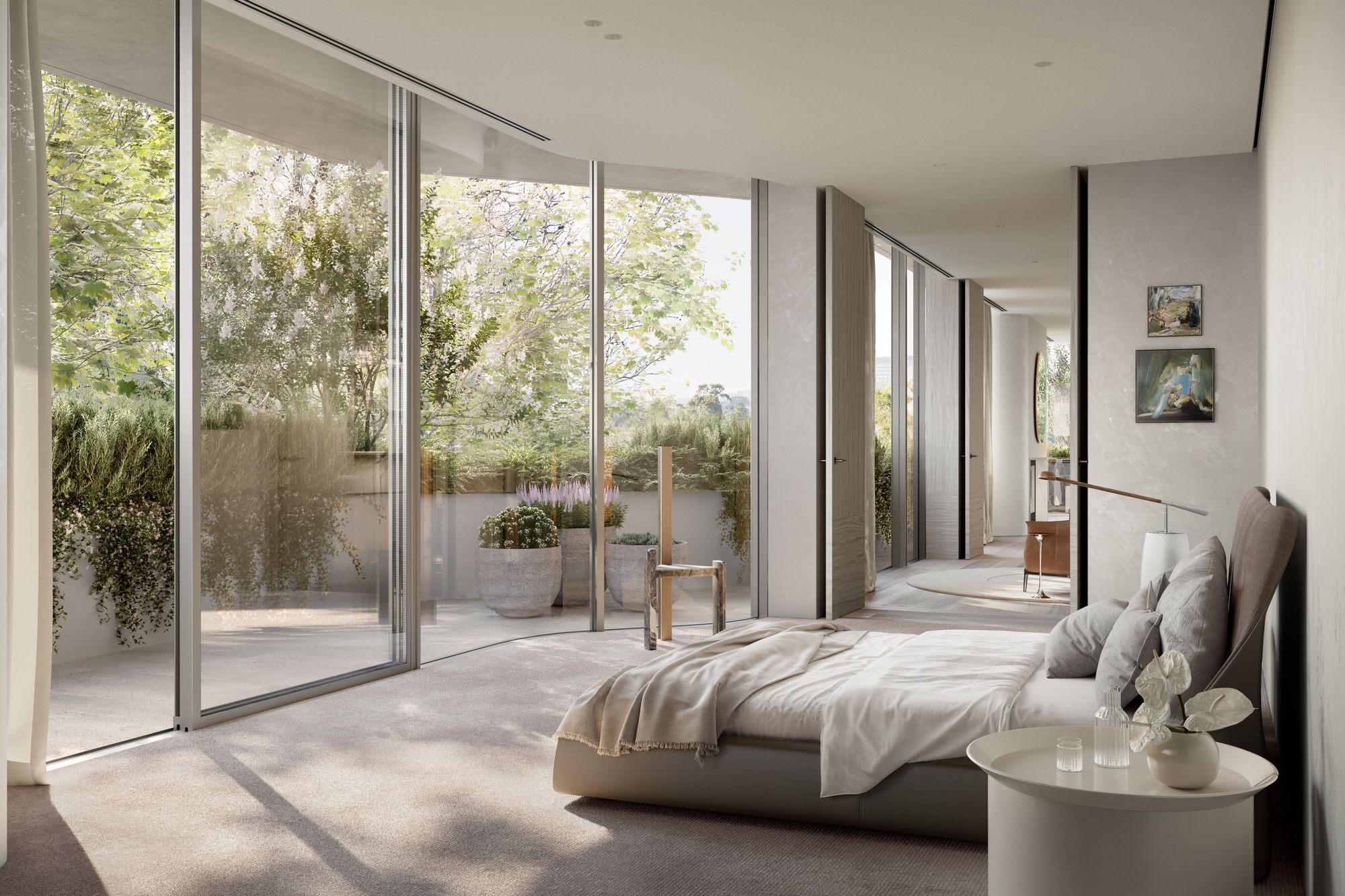 Como Toorak by Prime Edition x Jolson.  modern and minimalist interior that appears to be a bedroom with a seamless transition to an outdoor space. The room is characterized by a neutral color palette, with light walls and a soft beige carpet that adds warmth to the space. The furnishings are simple and elegant, including a low-profile bed, a plush chair, a small side table with a vase and some books, and a wooden chair with a woven seat, which introduces a natural element into the room.