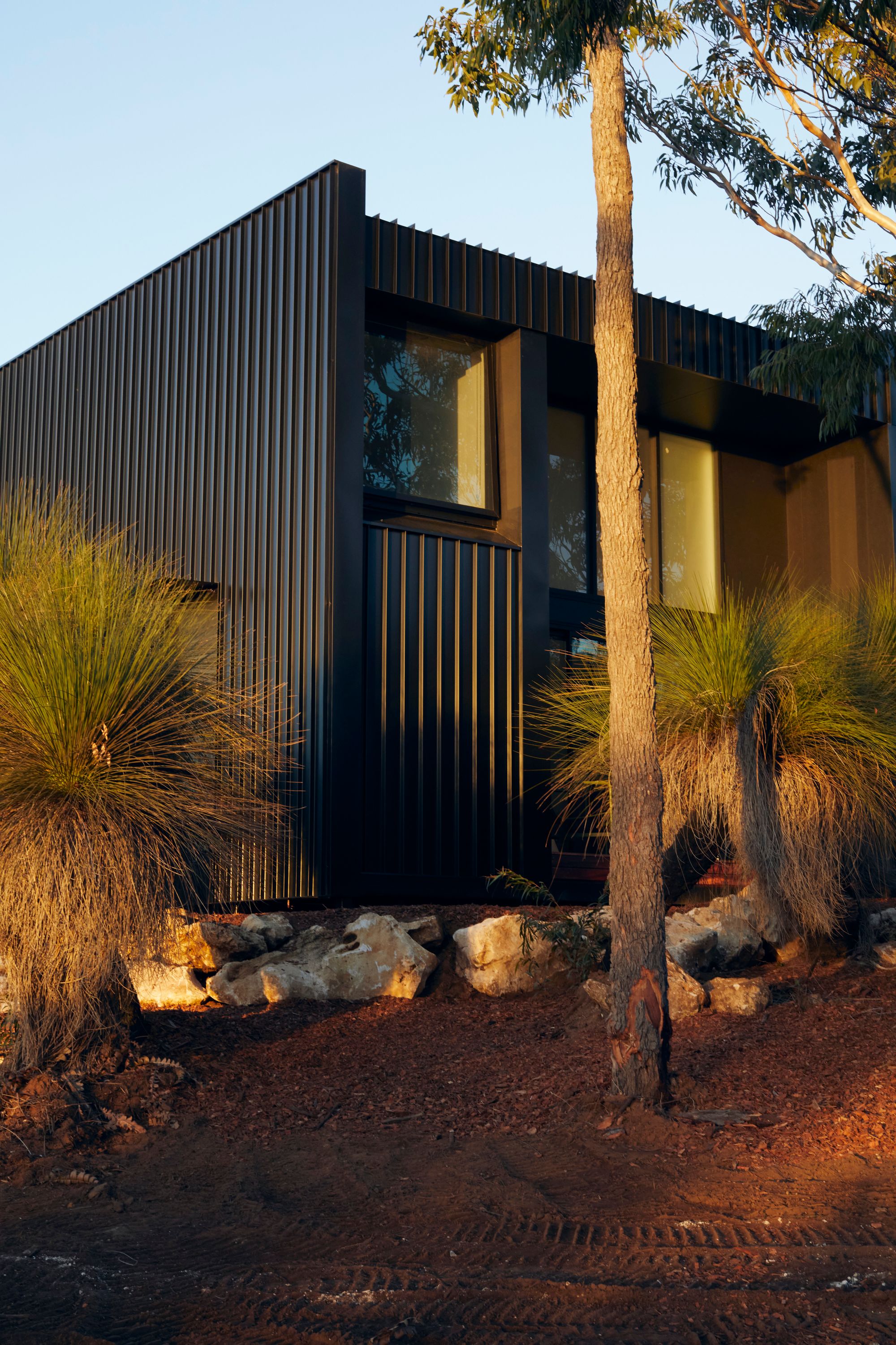 An exterior view of DEN PLACE showing the building sitting in the Australian landscape