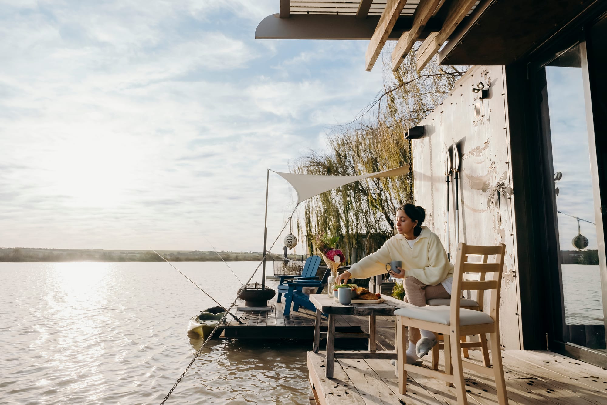 Bill's Boathouse. A view from the deck showing a woman enjoying a breakfast outside