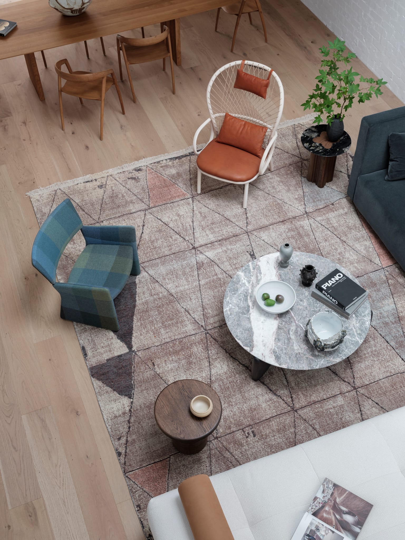 Bellevue House by Carla Middleton Architects. Photography by Tom Ferguson. Aerial of living room with geometric inspired print rug and assorted couches, armchairs, coffee tables and side tables. Timber floors. 