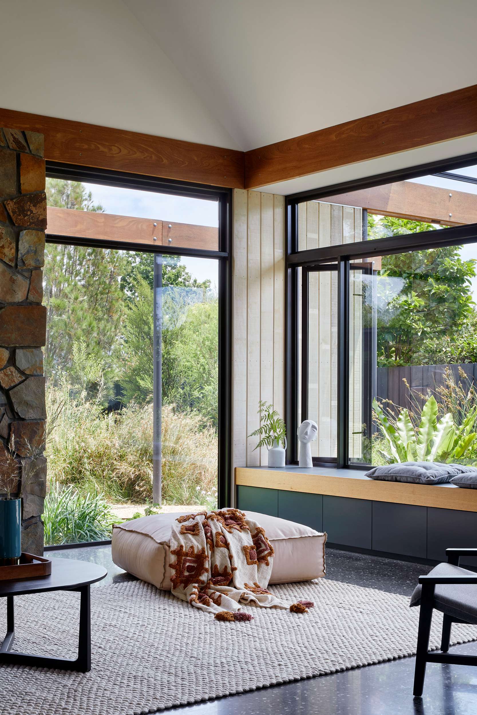 An interior shot of the living room showing the window seat and large windows showing the landscape