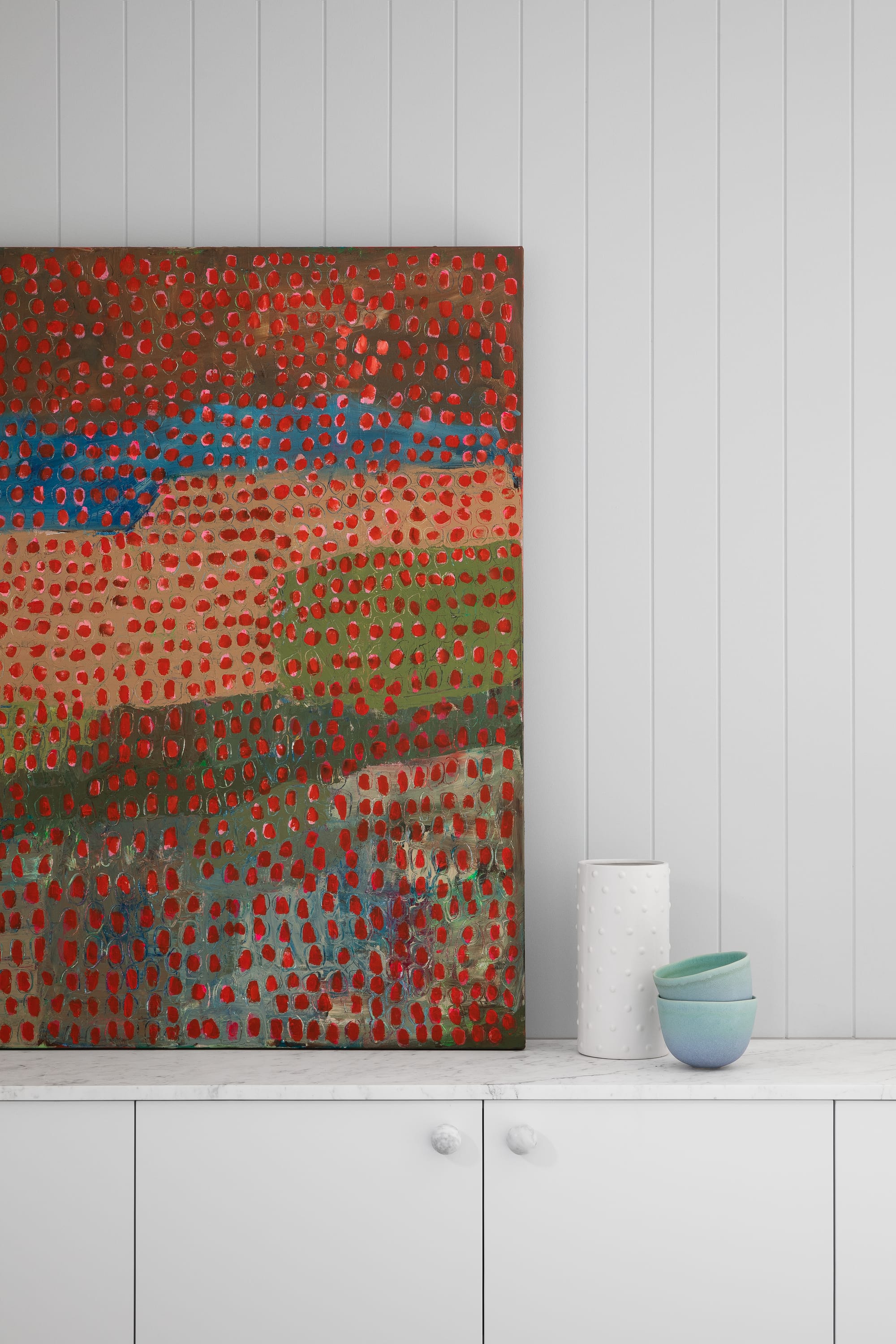 Stead House by Hannaford Design Studio. Photography by Emily Bartlett. Close up of dot painting on grey cabinetry bench. Stone benchtop. Grey clad walls. 